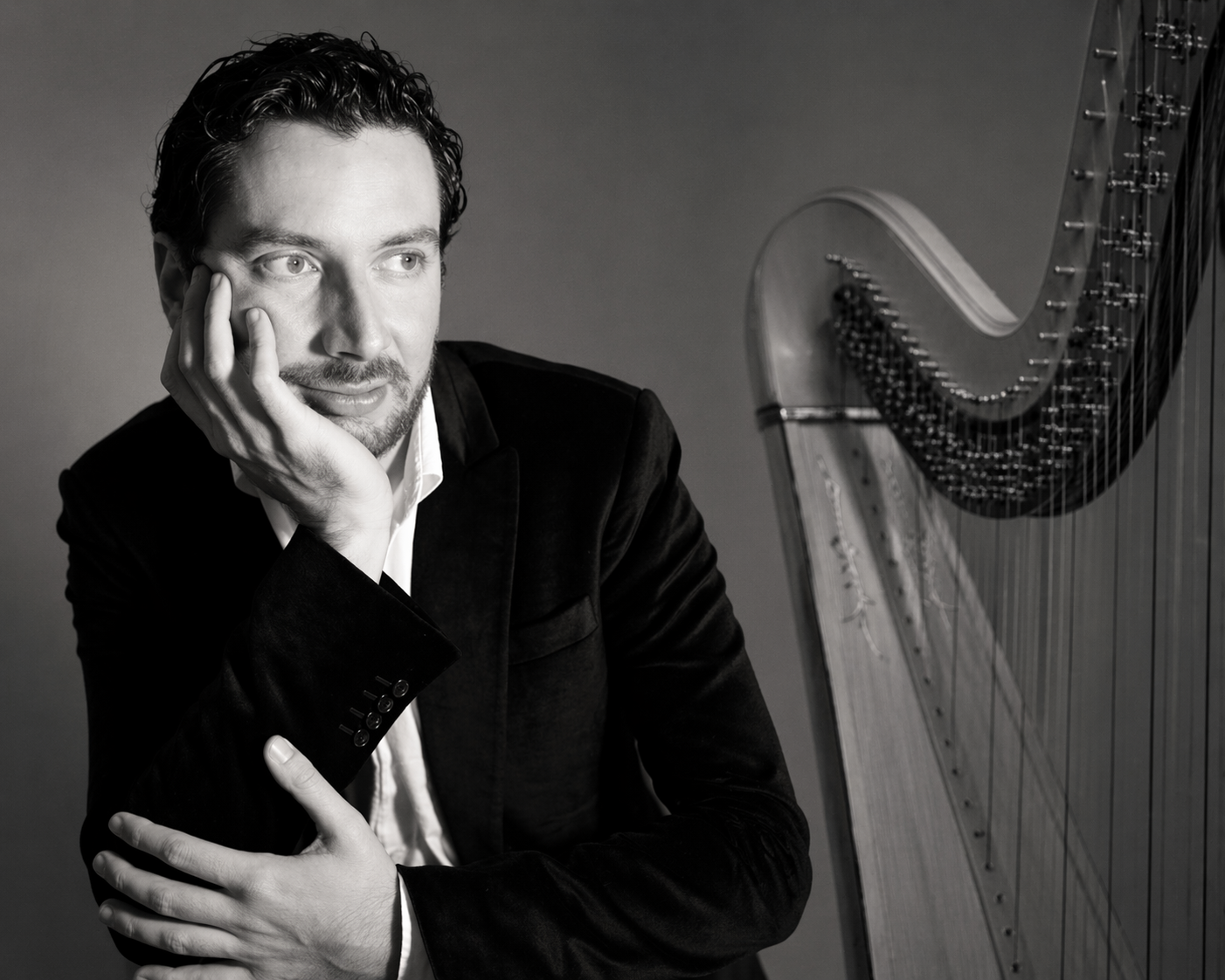 image en noir et blanc du musicien julien marcou avec sa harpe